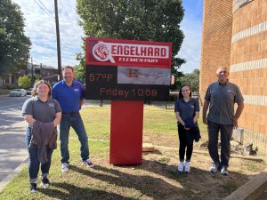 Four Louisville, Kentucky, BCers check out Engelhard Elementary's new electronic curbside sign that they donated funds to.